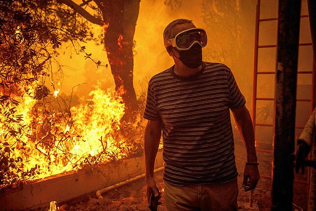 Ein Mann beobachtet, wie sich die Flammen des Palisades-Feuers seinem Grundstück im Stadtteil Pacific Palisades von Los Angeles nähern.