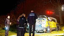 Einsatzkräfte der Polizei stehen vor dem Wrack des Unfallfahrzeugs. Ein 19-jähriger Autofahrer ist an einem beschrankten Bahnübergang in ...