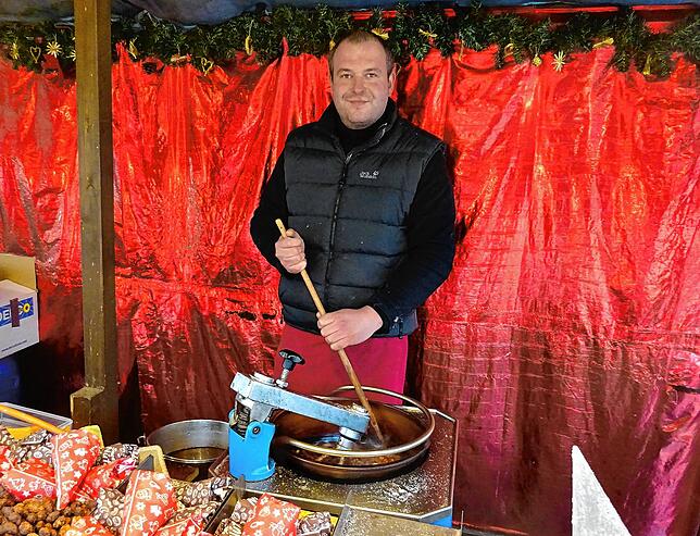 Dominik Slodnik steht an seinem Stand mit gerösteten Mandeln: Der Röstautomat und der kleine Heizstrahler, der die Mandeln warmhält, ...