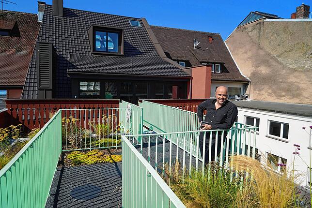 Dachterrasse zwischen Altstadtmauern: Architekt Kai Flender steht auf der Dachterrasse zwischen den beiden sanierten Gebäuden ...
