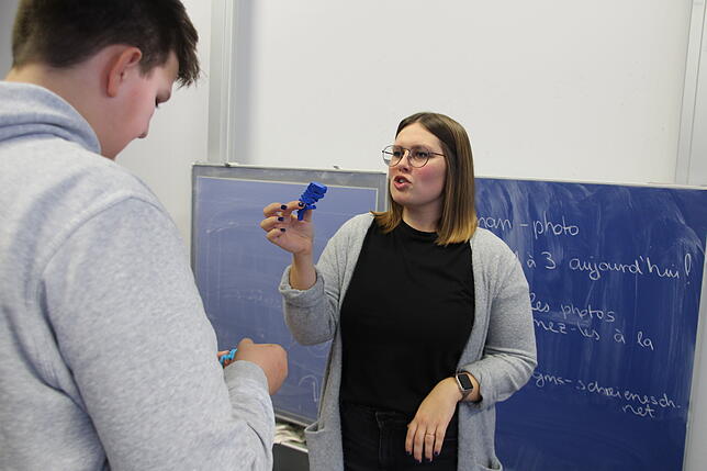 Sarah Neumeyer zeigt Schülern der Häfler Schreienesch-Schule den &bdquo;Flexi-Rex&ldquo;. Der flexible, blaue Mini-Dinosaurier wurde am ...