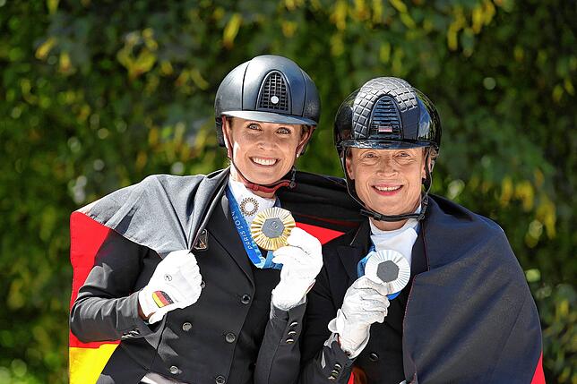 Deutschlands Jessica von Bredow-Werndl (l, Gold) und Isabell Werth (Silber) zeigen am 04.04.2024 nach der Siegerehrung ihre Medaillen.