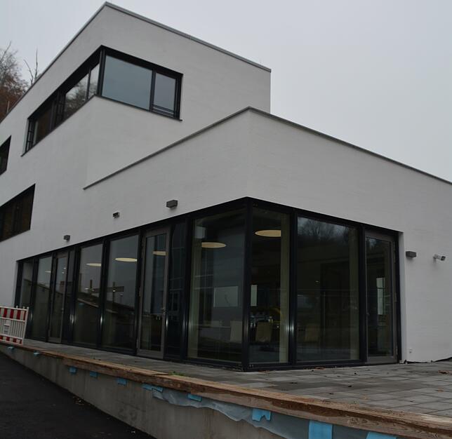 Die neue Mensa von außen, wo noch die Gestaltung der Anlagen im Gange ist.