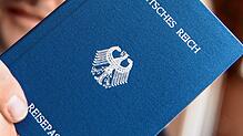 Ein Mann hält ein Heft mit dem Aufdruck &bdquo;Deutsches Reich Reisepass&ldquo; in der Hand. Ein mutmaßlicher Reichsbürger soll mehrere ...