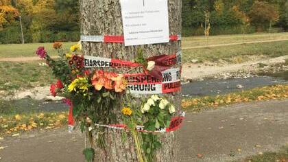Blumen und Trauerbekundungen finden sich an einem Baum in der Nähe des Tatorts in Freiburg. Bild: Uli Homann