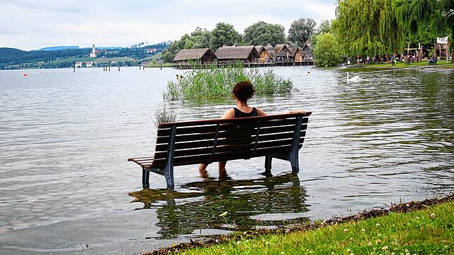 Ruhepause mit Fußbad: Der Uferbereich in Unteruhldingen steht am Sonntag unter Wasser. In den Pfahlbauten (im Hintergrund) bestand keine ...