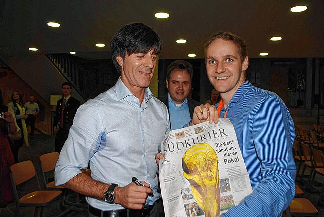 SÜDKURIER News-Manager Tobias Kaiser (rechts) lässt im Jahr 2014 den Weltmeister-Trainer auf der historischen Titel-Seite unterschreiben.