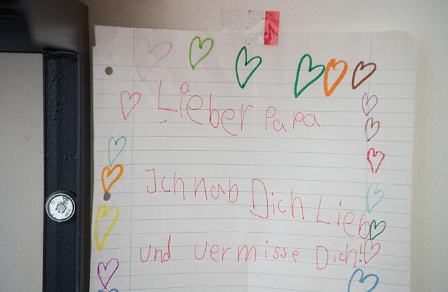 Ein gemalter Brief mit der Aufschrift "Lieber Papa Ich habe Dich lieb und vermisse dich" hängt an der Wand einer Einzelzelle eines ...