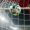 Ein Fußball fliegt ins Netz.