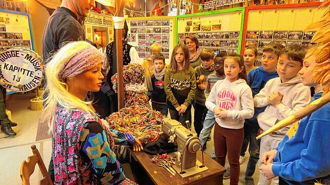 Die Kinder der Kirchen-Hausener Grundschule besuchen die Ausstellung der Narrenzunft. Zunftmeister Christoph Moriz erklärt ihnen und ...