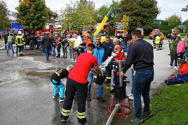Die Feuerwehr band die Zuschauer mit in die Übung ein und forderte sie auf, wie früher eine Kette zu bilden, um einen Brand mit ...