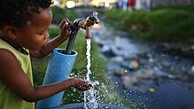 Ein Junge trinkt Wasser aus einer kommunalen Trinkwasserquelle. Dieses Jahr droht Kapstadt keine Abschaltung der Wasserversorgung.