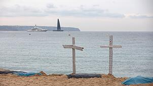 Mit symbolischen Grabkreuzen protestieren Rettungsschwimmer am Strand von Can Pere Antoni auf Mallorca. Seit dem 28. September befinden ...