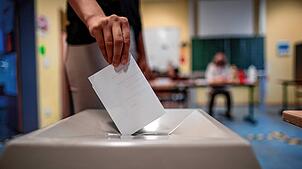 Eine Frau wirft einen Wahlzettel in eine Wahlurne in Düsseldorf. Rund 13,7 Millionen Bürger dürfen diesen Sonntag an den Kommunalwahlen ...