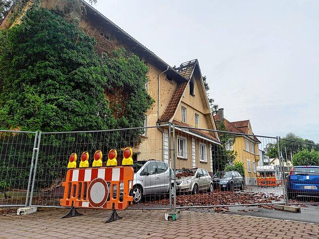 Die Brandstelle am Sonntagmorgen: Dachziegel sind auf der Straße und auf parkenden Autos gelandet.