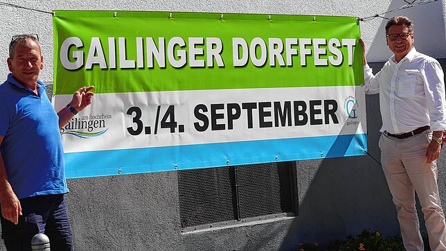 Sie halten das Dorffest-Banner hoch: Bürgermeister Thomas Auer und Uwe Unger vom Orga-Team freuen sich, dass die Veranstaltung nach den ...