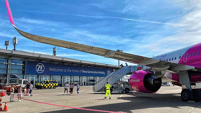Passagiere steigen am Flughafen Friedrichshafen aus einem Flugzeug aus.