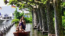 Vier Kinder paddeln im Mai 1999 mit einem Boot über die überflutete Uferpromenade in Unteruhldingen am Bodensee. Bei dem ...
