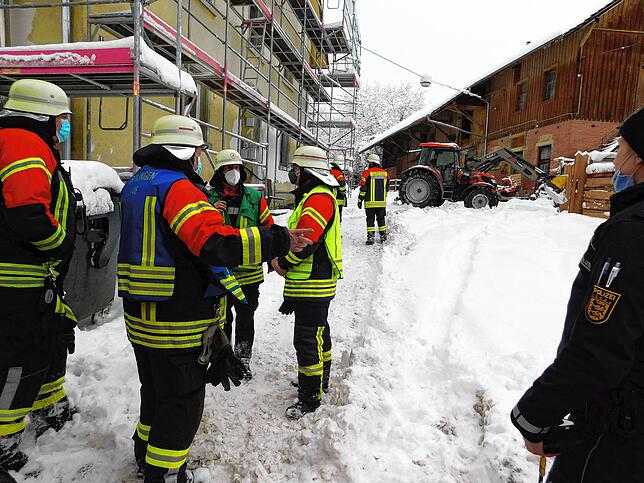 Mit Mundschutz und Helm ausgerüstet, prüft die Feuerwehr Überlingen im Januar 2021 die Statik eines Stallgebäudes im Gewann Reutemühle.
