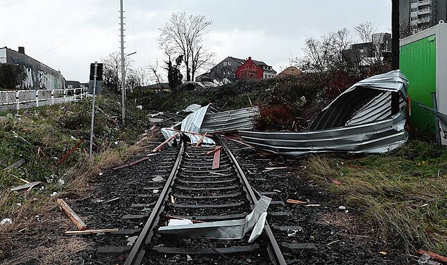 Teile von abgedeckten Dächern und Hallen liegen auf Gleisen der Bahn in Köln.