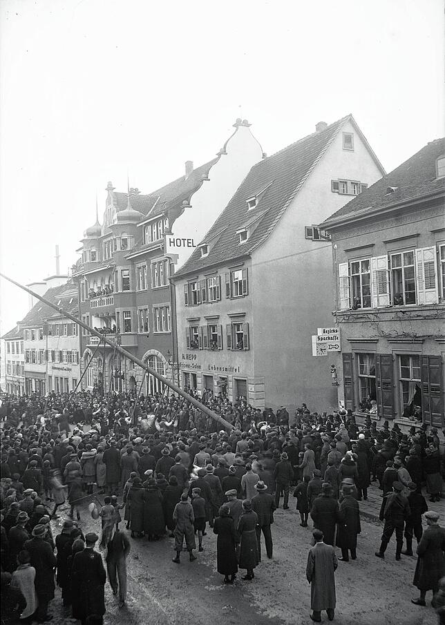 Narrenbaumsetzen am Lebensmittel-Geschäft G. Stocker und Friseur-Salon H. Hepp am 16.02.1939. Glasplatten-Negativ. Das Schild an der ...