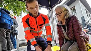 Alexander Kollnberger zeigt Renate Schwarzwälder am Dummy, wo man wie für die Herz-Druck-Massage drücken muss.