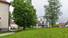 Auf diesem Grundstück neben der Schule (links) und dem landwirtschaftlichen Gebäude (rechts) soll ein Mehrfamilienhaus wie im ...