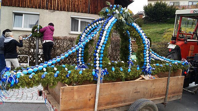 Per Traktor wird die Osterkrone zu ihrem Brunnen in Leustetten gefahren. Einwohner haben sie mit zahlreichen bemalten Eiern geschmückt.