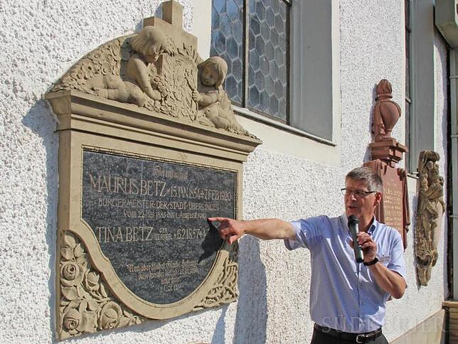 An der Seitenwand der Kapelle befinden sich Ehrengrabmäler verdienter Bürger: Hier von Bürgermeister Maurus Betz und Landrat Hermann ...