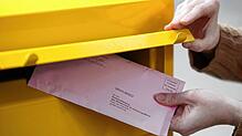 Eine Passantin steckt ihre Briefwahlunterlagen zur Bundestagswahl in einen Briefkasten. (Symbolbild) Ein Briefkasten mit Wahlunterlagen ...