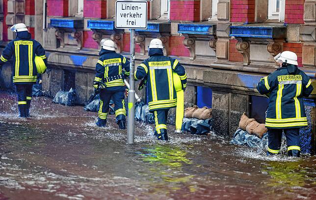 Einsatzkräfte der Feuerwehr sind in Aktion in der Innenstadt von Flensburg. Hier eignete sich in der Nacht ein Jahrhunderthochwasser.