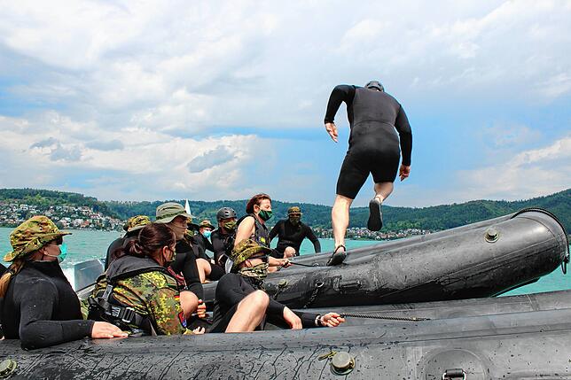 Der Soldat rennt sicher über die vier zusammenliegenden Boote. Die Schiffsführer sorgen dafür, dass sie dicht beeinander bleiben und ...