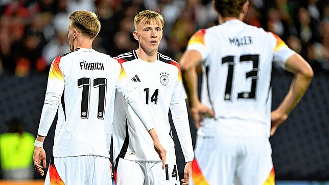 Chris Führich, Maximilian Beier und Thomas Müller stehen nach dem Spiel auf dem Feld.