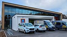 Viele Handwerkerfahrzeuge stehen derzeit vor dem neuen Aldi, für den nun ein Eröffnungstermin feststeht.
