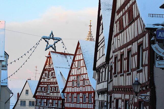 Da kommt vorweihnachtliche Stimmung auf: Die verschneiten Dächer der Fachwerkhäuser in der Hauptstraße mit Weihnachtsbeleuchtung.