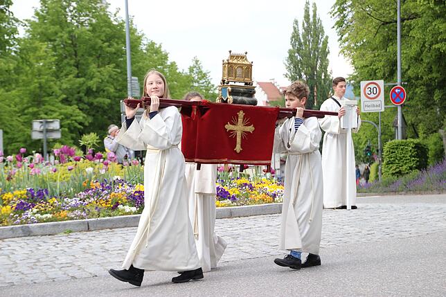 Ministranten tragen einen Reliquenschrein.