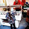 Ein Mitarbeiter gibt einem Kind einen Joghurt in der Ausgabestelle der Berliner Tafel. Im monatelangen Streit über die Einführung einer ...
