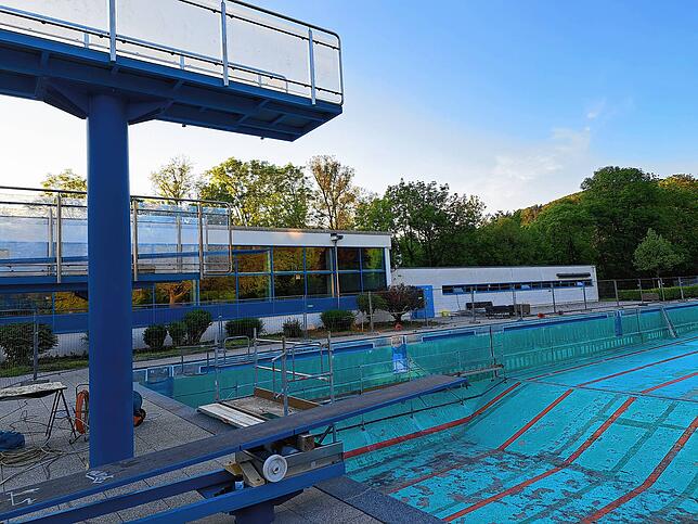 Das leere Schwimmerbecken mit Sprungturm.