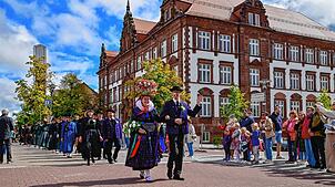 Das gab es zuletzt vor über 75 Jahren. Der Hochzeitszug des Trachtenvereins zieht mit echtem Brautpaar am historischen Schulgebäude ...