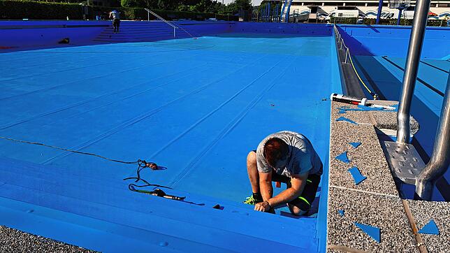 Noch kein Wasser drin. Im Nichtschwimmerbecken im Freibad Wehr werden letzte kleine Folienkanten an den Treppenstufen verschweißt.