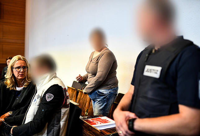 Der wegen Kindesmissbrauchs angeklagte Lebensgefährte (2.v.l) und die angeklagte Mutter (2.v.r) in einem Saal des Landgerichts, links ...