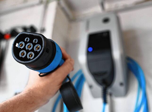 E-Auto-Stecker in einer Garage. Wie koppelt man E-Autos am besten mit PV-Anlagen?