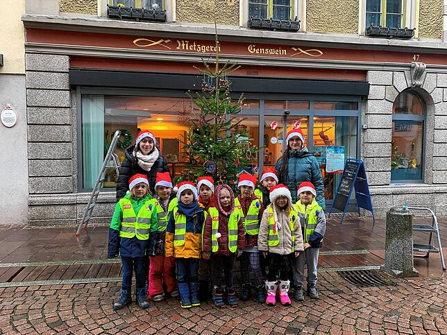 Die Kinder des Kinderlands Tiengen stehen vor ihrem Weihnachtsbau, den sie in der Innenstadt geschmückt haben.