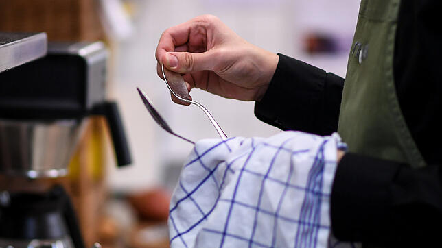 Ein Auszubildender trocknet Besteck ab. In Betrieben, die mit Lebensmitteln arbeiten, spielt Hygiene eine äußerst wichtige Rolle. ...