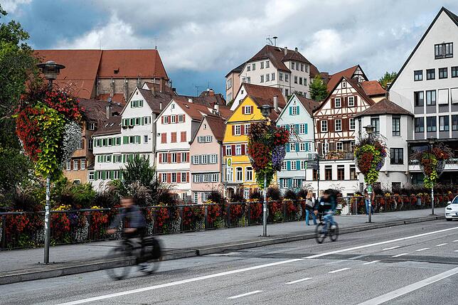 Fachwerkidylle: Radfahrer fahren über eine Neckarbrücke in der Tübinger Innenstadt.