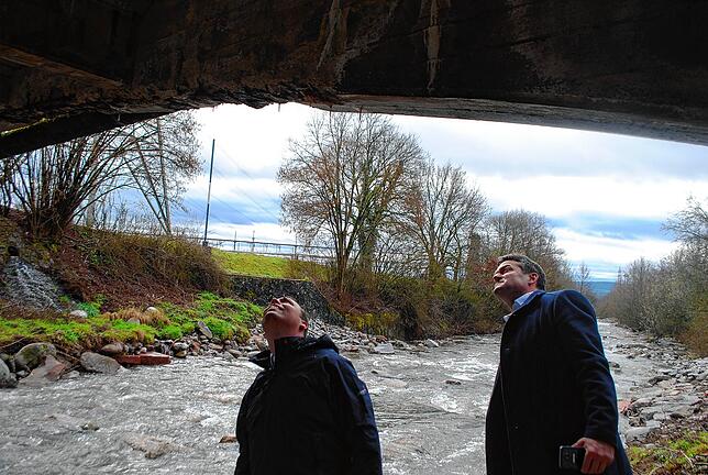 Claudio Helling (links) und Joachim Baumert begutachten die Schäden an der Unterseite der Schlüchtbrücke.