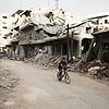 Afrin nach der türkischen Militäroffensive: Ein Junge fährt auf seinem Fahrrad an zerstörten Häuserfronten vorbei.
