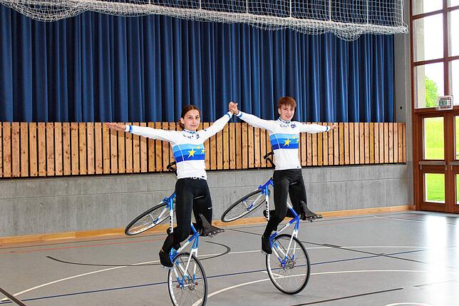 Lena und Eva Streit (von links) zeigen den Kehrlenkersitzsteiger, die Startposition für die zweifache Standdrehung.