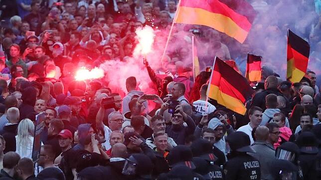 Demonstranten zünden in Chemnitz Pyrotechnik und schwenken Deutschlandfahnen. Foto: Jan Woitas