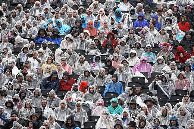 Trotzten dem Regen: etliche Zuschauer mit Regenponchos warten auf der Tribüne gegenüber dem Buckingham Palace während der ...